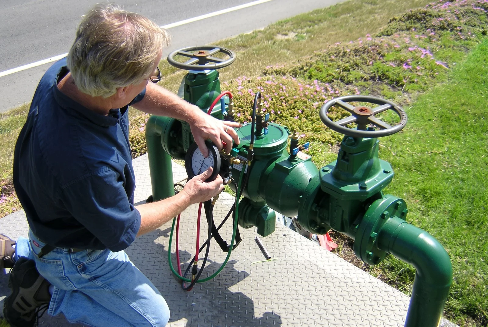 Technician testing a backflow prevention valve with pressure gauges